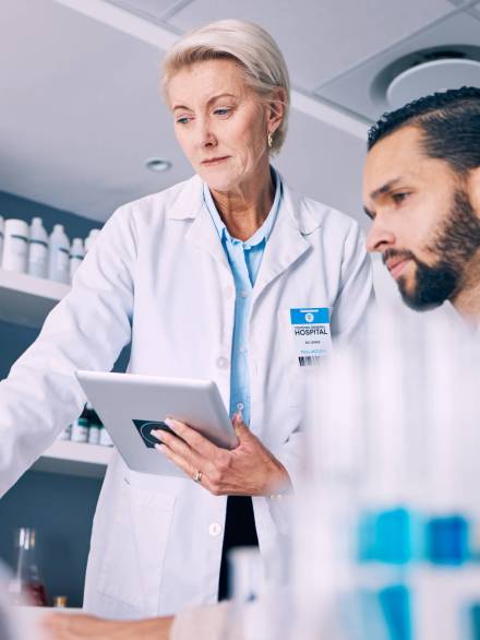 Scientist, mentor and training on tablet for data analysis, laboratory report and pharmaceutical re.
